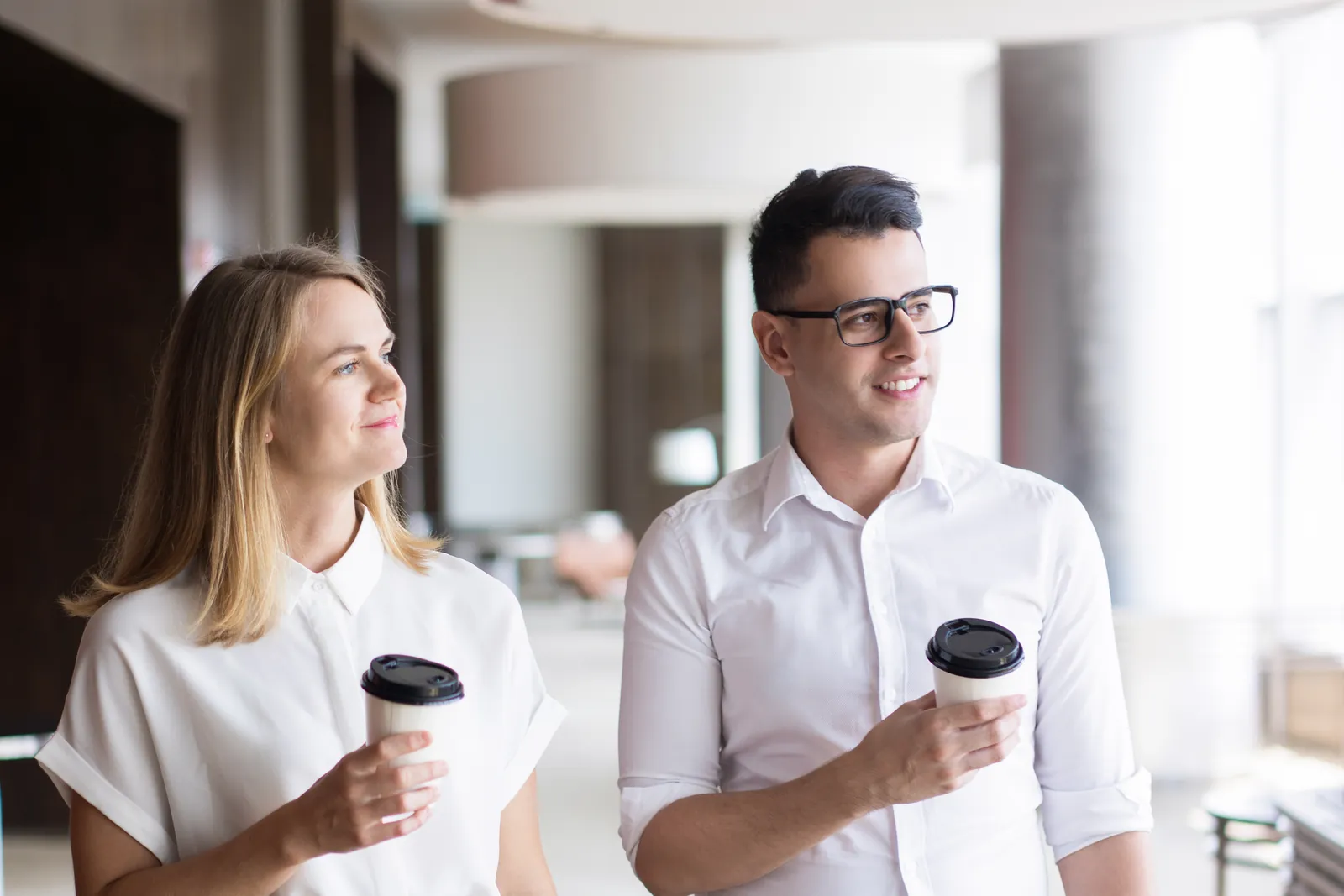 Two Finfident team members walking through the office with coffee